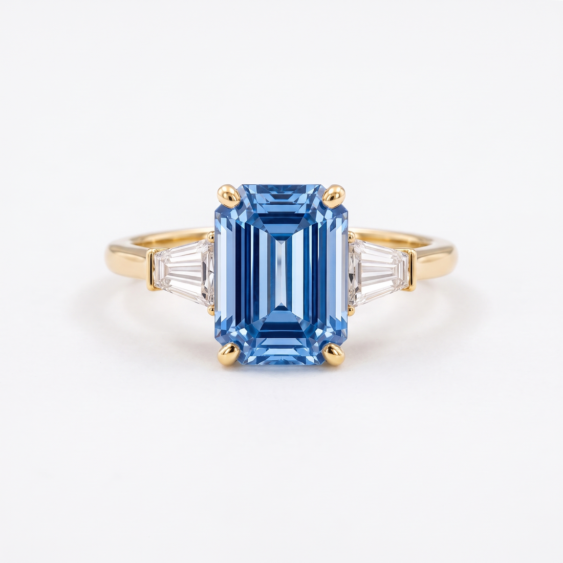Blue emerald-cut lab-grown diamond three-stone engagement ring catalog hero on white background