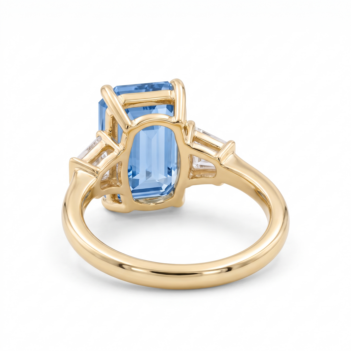 Blue emerald-cut lab-grown diamond three-stone engagement ring rear three-quarter catalog view on white background