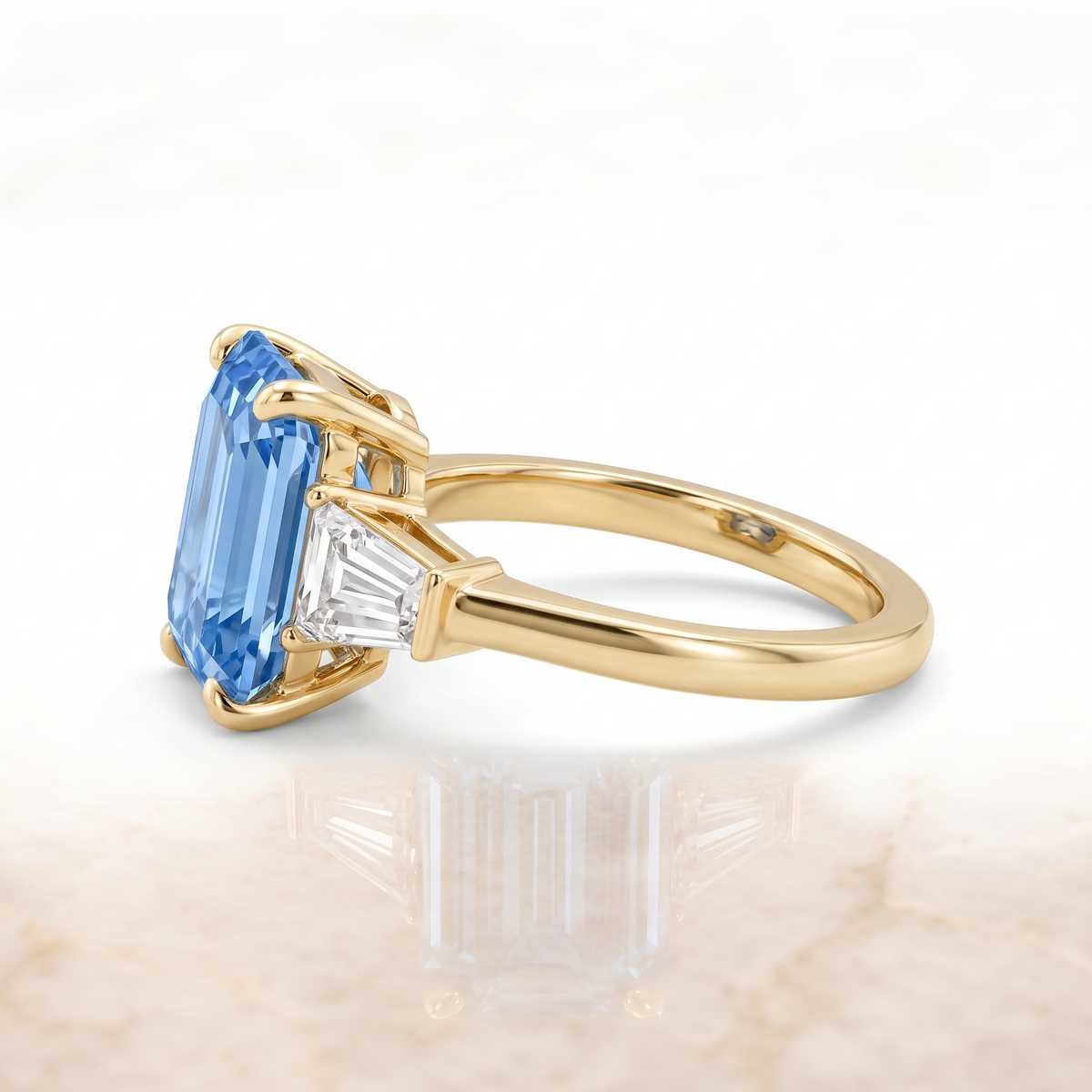Blue emerald-cut lab-grown diamond three-stone engagement ring side catalog view on white background