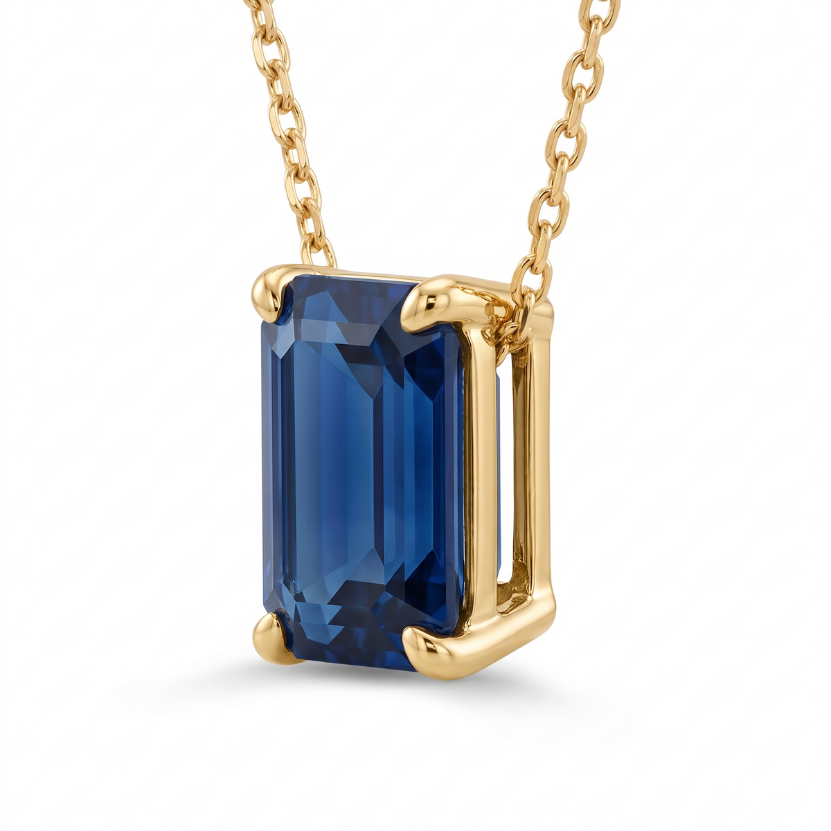 Emerald-cut blue sapphire solitaire necklace, angled setting view — AI-generated design representation