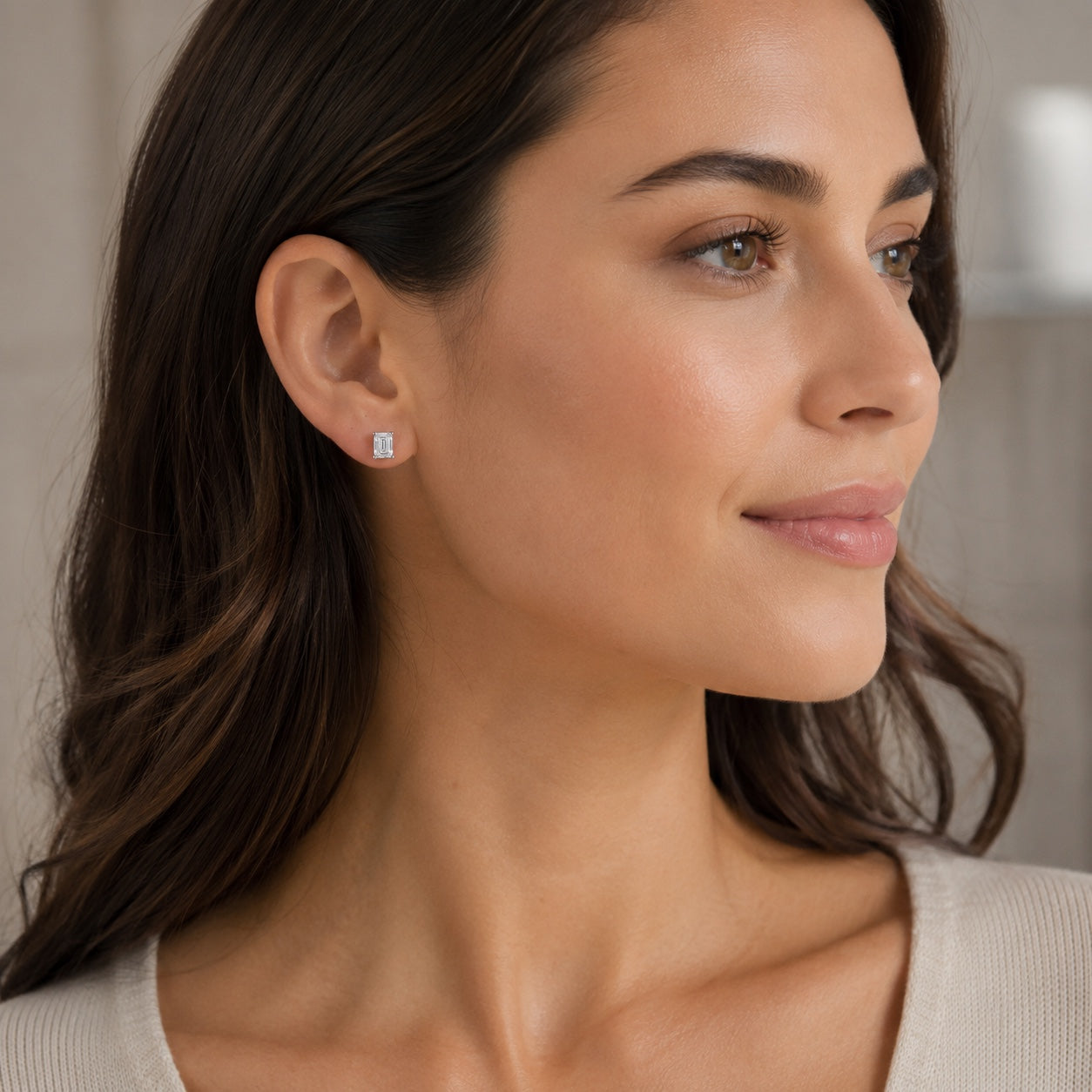 Design render of a woman wearing emerald-cut 1.00 CTW lab-grown diamond stud earrings in 14K white gold