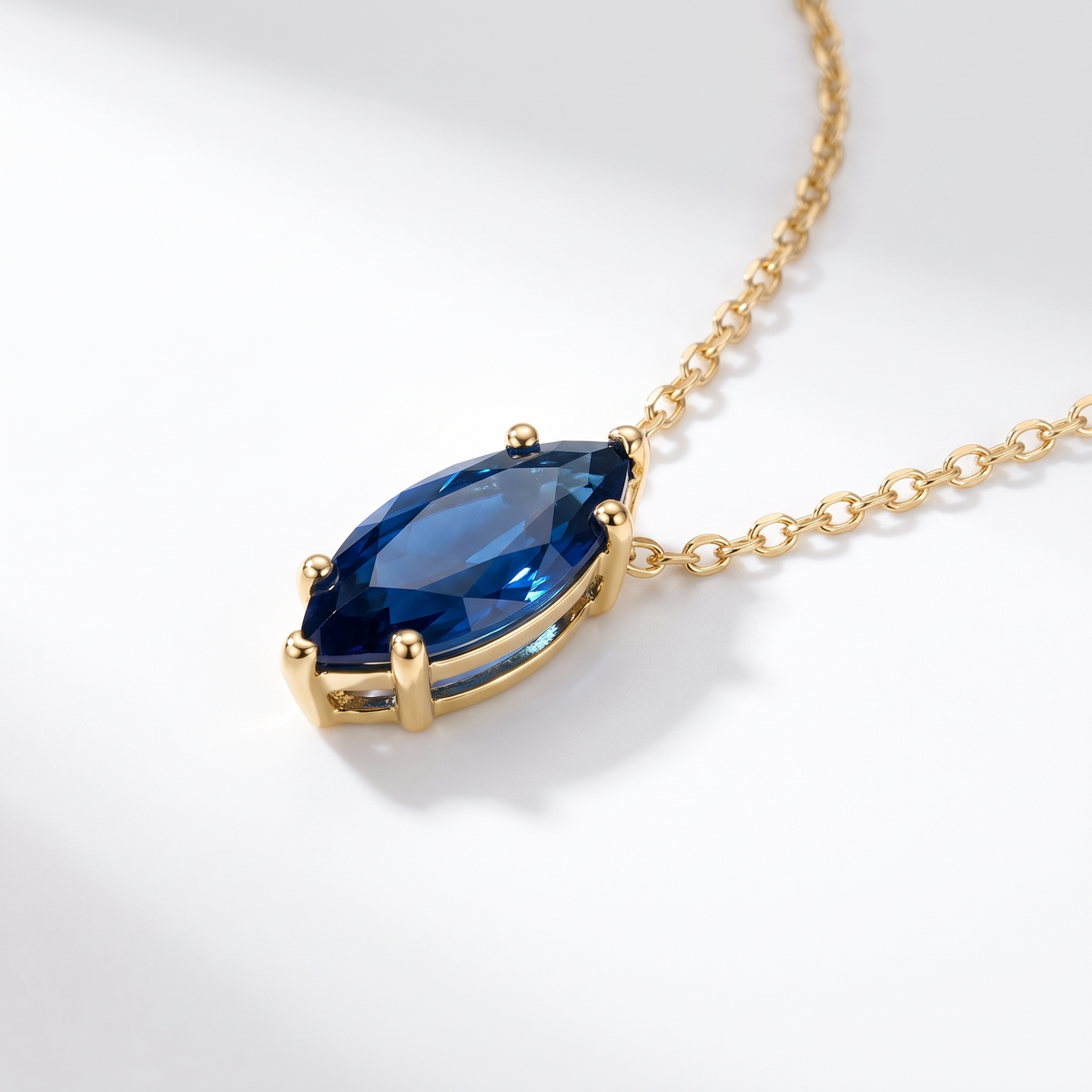 Marquise-cut blue sapphire solitaire necklace, angled front detail — AI-generated design representation