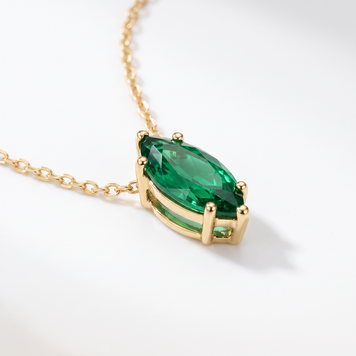 Marquise-cut emerald solitaire necklace, gemstone and setting detail — AI-generated design representation