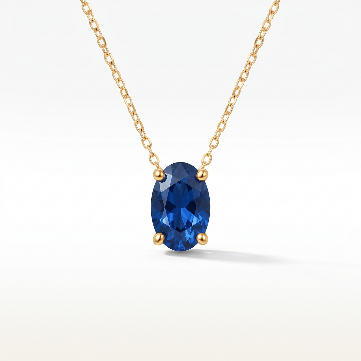 Oval-cut blue sapphire solitaire necklace in solid gold, catalog view — AI-generated design representation