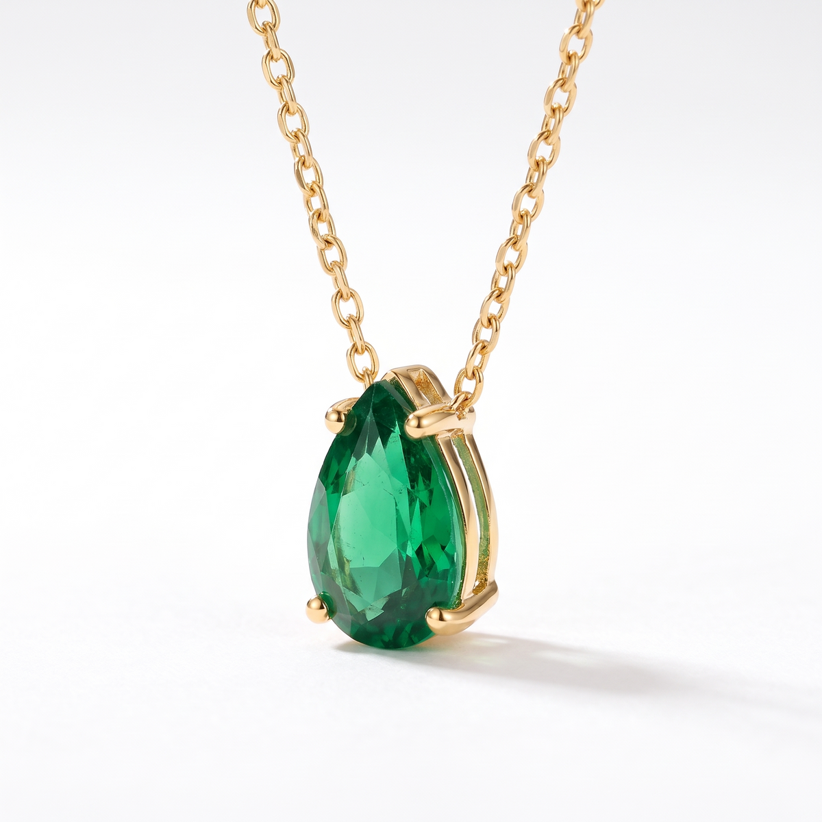 Pear-cut emerald solitaire necklace, angled front detail — AI-generated design representation