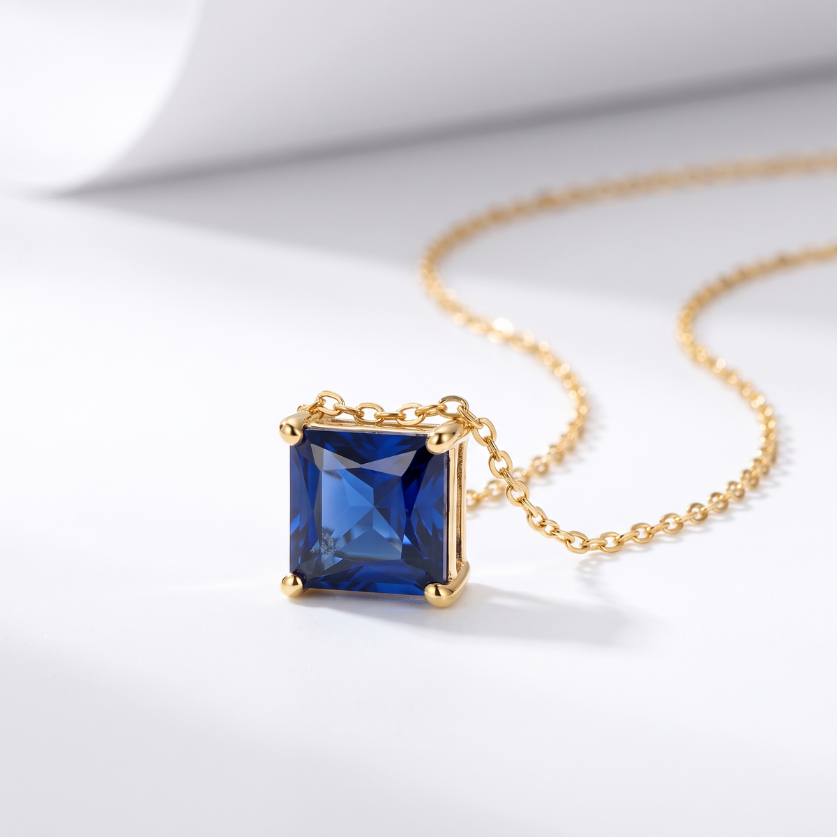 Princess-cut blue sapphire solitaire necklace, angled front detail — AI-generated design representation