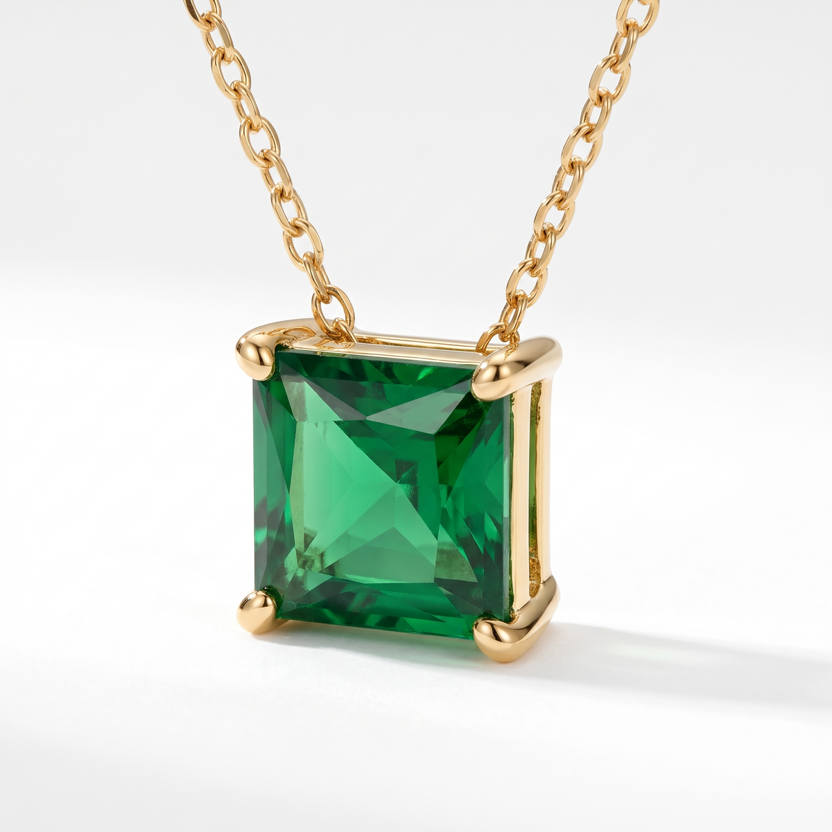 Princess-cut emerald solitaire necklace, angled front detail — AI-generated design representation