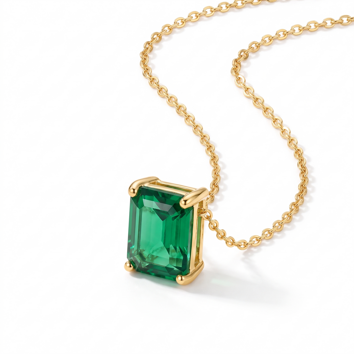 Radiant-cut emerald solitaire necklace in solid gold, catalog view — AI-generated design representation